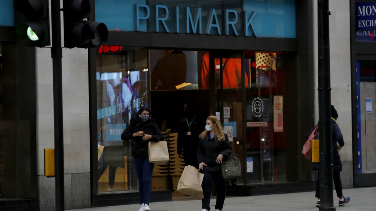 Women carry shopping bags as they leave a Primark clothes store on Oxford Street. 