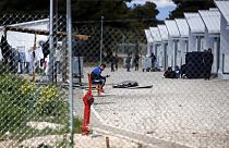 FILE - Migrants gather outside their container houses t a refugee camp in Ritsona about 80 kilometers (50 miles) north of Athens, Thursday, April 2, 2020.