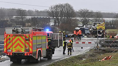 Policemen and railway inspectorate staff work at the scene of a train crash where a fast train collided with a truck at a level crossing in Dolni Lutyne, Czech Republic