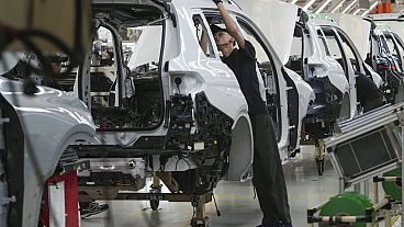An employee works on a car on the assembly line at the BMW Production Network 2 at Gaya Motor plant in Jakarta, Indonesia, Tuesday, June 6, 2023. (AP Photo/Tatan Syuflana)