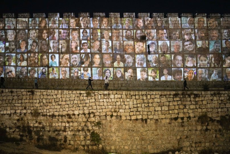 Fotos von israelischen Geiseln, die von militanten Hamas-Kämpfern festgehalten werden, werden auf die Mauern der Altstadt von Jerusalem projiziert, November 2023