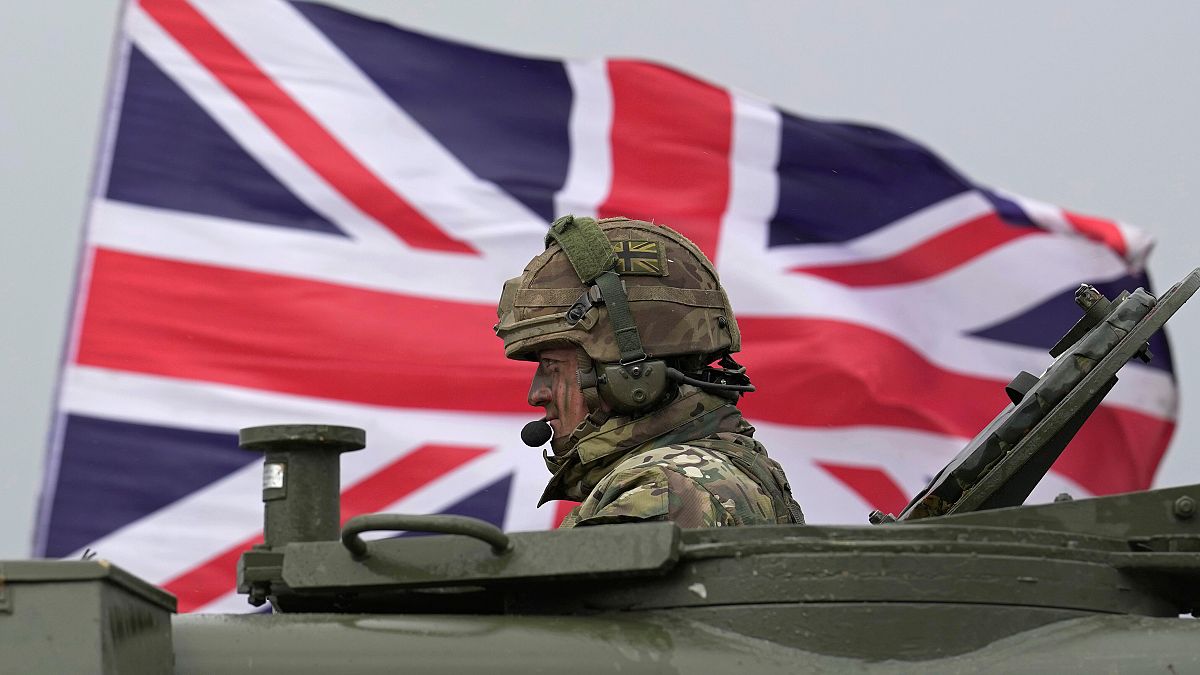 Um soldado britânico senta-se num AS90 enquanto participa num exercício militar com soldados ucranianos num campo de treino militar em Inglaterra.