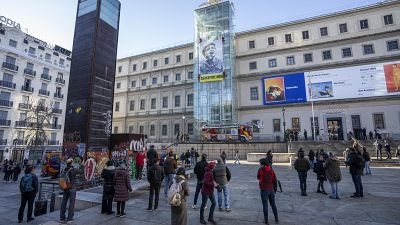 Greenpeace activists hang a banner showing a Palestinian child crying for help outside the Reina Sofia museum in Madrid