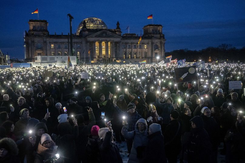 FILE- People hold up their cell phones as they protest against the AfD party and right-wing extremism in front of the Reichstag building in Berlin, 21 January 2024.