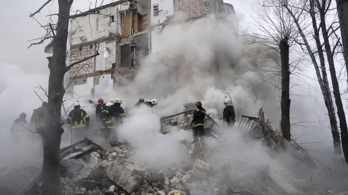 Einsatzkräfte vor einem zerstörten Gebäude in Charkiw am 23.01.2024