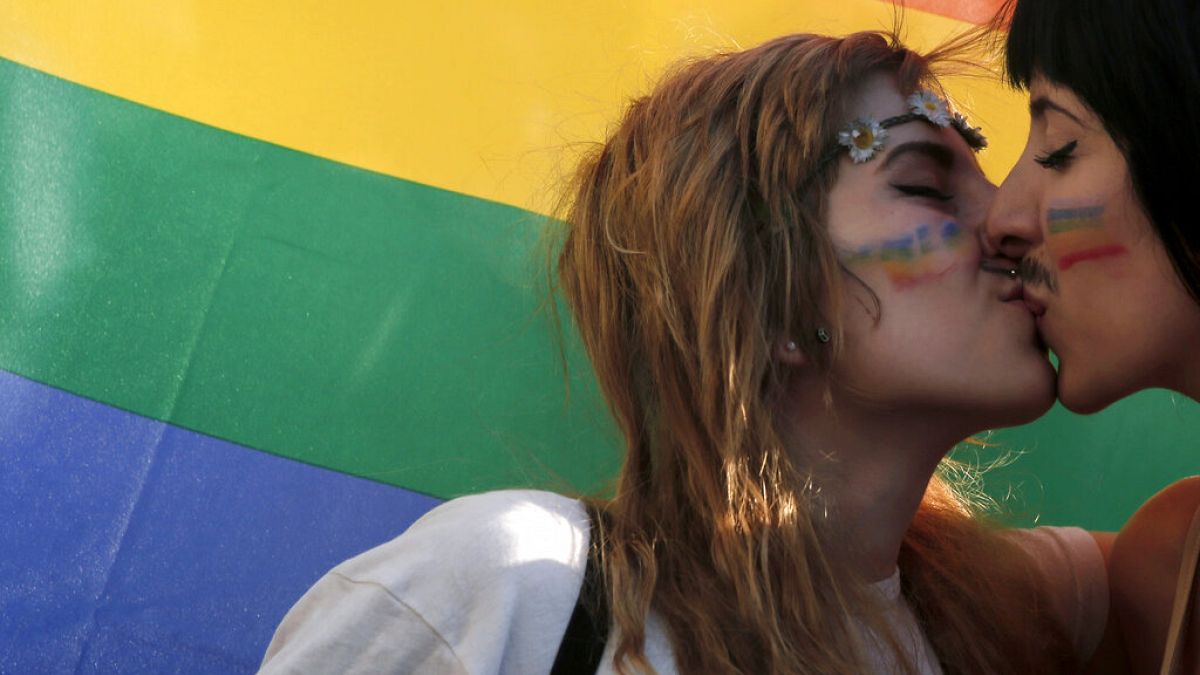 Yunanistan'ın başkenti Atina'da düzenlenen Eşcinsel Onur Yürüyüşü sırasında iki kadın, eşcinsel hakları hareketinin sembolü olan gökkuşağı bayrağının önünde öpüşürken