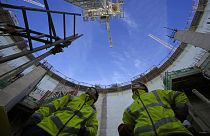Employees look up at the construction site of Hinkley Point C nuclear power station in Somerset, England, Tuesday, Oct. 11, 2022.