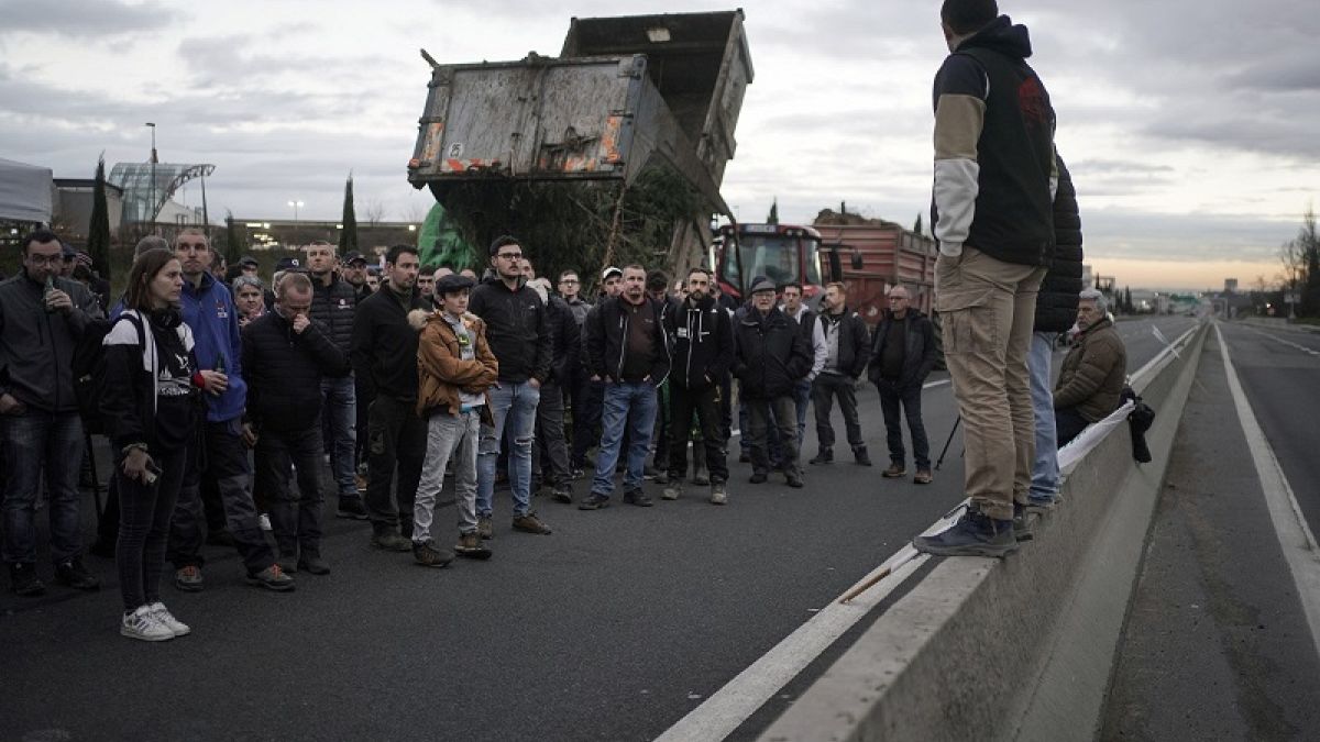Los agricultores escuchan un discurso mientras bloquean la autopista M6 cerca de Lyon, centro de Francia, el miércoles 24 de enero de 2024.