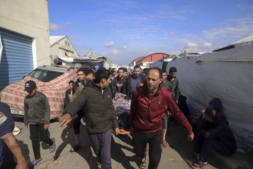 Palestinians carry a a body of a person killed in the Israeli bombardment at a building of an UNRWA vocational training center which displaced people use as a shelter.