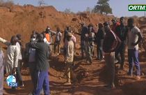 Un grupo de malienses observan el área donde se produjo el colapso de una mina de oro, enero de 2024.