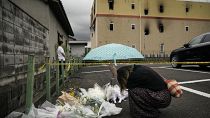 امرأة تصلي أمام نصب تذكاري مؤقت لتكريم ضحايا حريق مبنى أستوديو كيوتو للرسوم المتحركة 