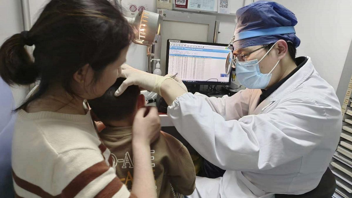 Le Dr Yilai Shu examine un jeune patient à l'hôpital de l'université de Fudan à Shanghai, en Chine, après une procédure de thérapie génique pour une surdité héréditaire.