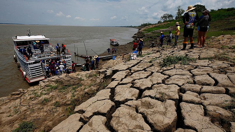 Les habitants d'une communauté riveraine transportent de la nourriture et de l'eau pour affronter à la sécheresse qui sévit à Careiro da Varzea, dans l'État d'Amazonas, Brésil