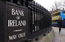 A woman walks past the offices of Bank of Ireland Monday Feb 20 2012.