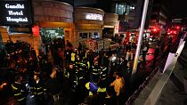 Medics and firefighters work outside Gandhi hospital after a huge fire erupted on multiple floors of the hospital, in northern Tehran, Iran, Thursday, Jan. 25, 2024