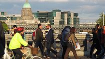 In this picture taken on Monday, Oct. 6, 2014, pedestrians and cyclists pass each other at evening rush hour on O'Connell Bridge in central Dublin.