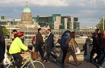 In this picture taken on Monday, Oct. 6, 2014, pedestrians and cyclists pass each other at evening rush hour on O'Connell Bridge in central Dublin.