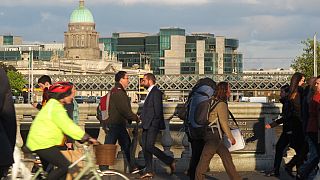 In this picture taken on Monday, Oct. 6, 2014, pedestrians and cyclists pass each other at evening rush hour on O'Connell Bridge in central Dublin.