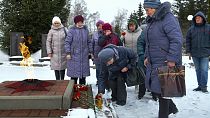 Women lay flowers in memory of those who were killed in the plane on Wednesday in Yablonovo, Belgorod region, Russia