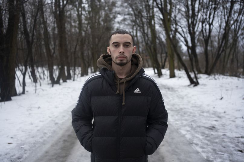 Illia, a 21-year-old former prisoner of war, stands in the forest close to the hospital where he undergoes treatment in Kyiv, Ukraine, Thursday, Jan. 25, 2024