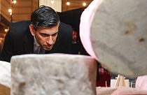 Britain's Prime Minister Rishi Sunak looks at cheeses as he visits a food and drinks market promoting British small businesses at Downing Street in London in 2022