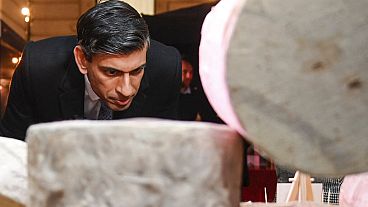 Britain's Prime Minister Rishi Sunak looks at cheeses as he visits a food and drinks market promoting British small businesses at Downing Street in London in 2022