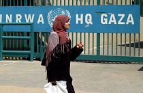 A woman walks past the UNRWA headquarters in Gaza