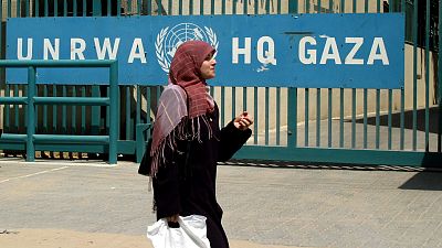 A woman walks past the UNRWA headquarters in Gaza