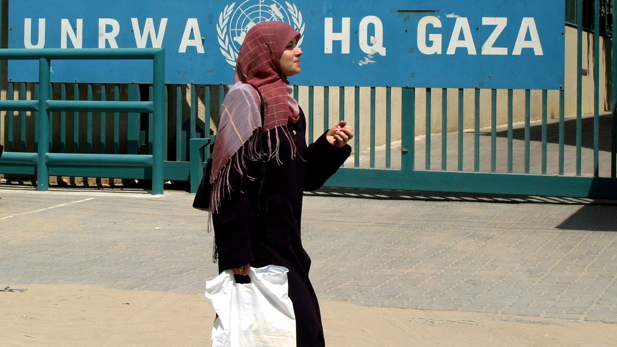 سيدة فلسطينية تسير بجوار مقر الأمم المتحدة لوكالة غوث وتشغيل اللاجئين الفلسطينيين (الأونروا) في مدينة غزة.