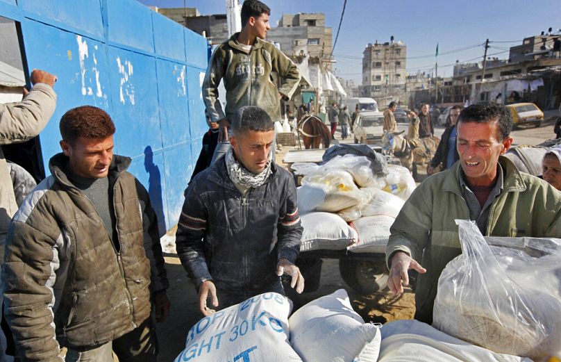 Gazze'de BM yardım ajansı UNRWA tarafından sağlanan gıda yardımını alan Filistinliler (arşiv)