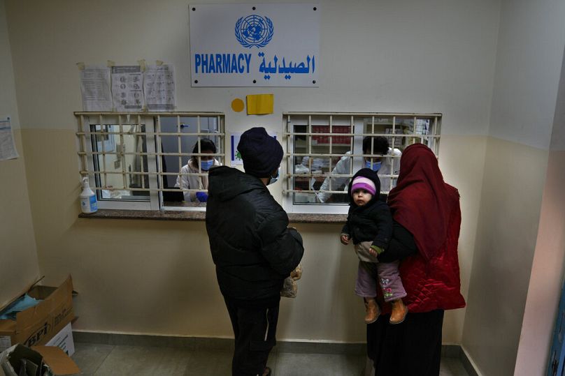 Lübnan'da bulunan Filistinli mülteci bir aile UNRWA tarafından sğalanan ilaçlarını almak için sırada beklerken