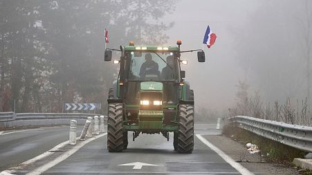 A farmer drives his tractor on a highway, near Agen, southwestern France, 27 January 2024. 
