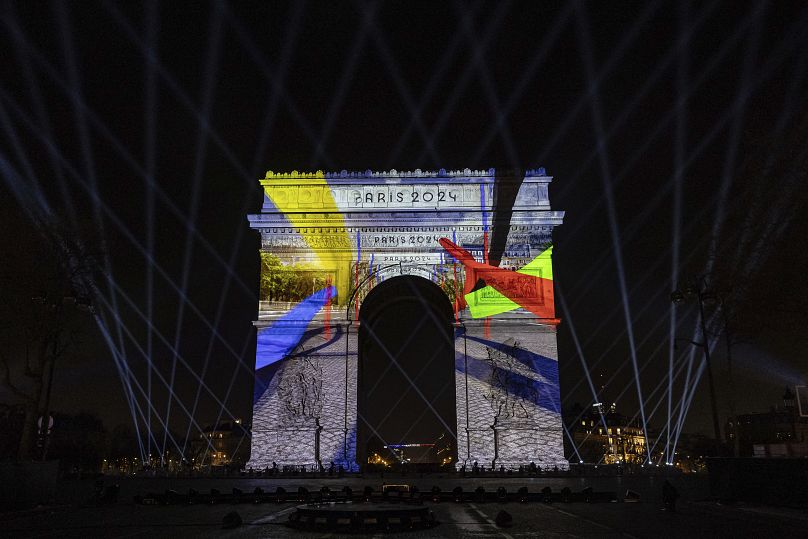 A video mapping is projected on the Arc de Triomphe to celebrate France's entry into the Olympic year, during New Year celebrations in Paris, Sunday, Dec. 31, 2023.