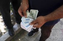 A street money exchanger poses for a photo without showing his face as he counts foreign banknotes in Ferdowsi street, Tehran's go-to venue for foreign currency exchange, Iran