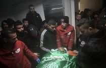 Palestinians gather around the body of Muhammad Jalamneh, draped in the Hamas militant group flag, in the morgue of Ibn Sina Hospital after he was killed.