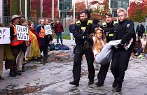 Police officers carry away an activist of the 'Letzte Generation' during a climate protest in Berlin, 31 October 2023.