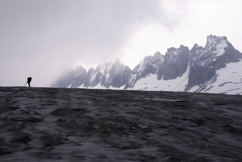 Un caméraman s'approche du glacier du Rhône près de Goms, en Suisse