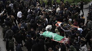 Numerosos ciudadanos marchan con los cuerpos de los tres milicianos de Hamás abatidos por soldados israelíes en el hospital Ibn Sina de la ciudad cisjordana de Yenín.