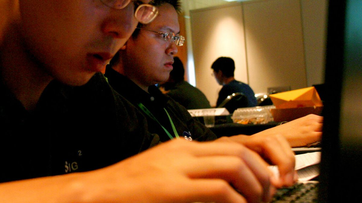 Singapur'da düzenlenen bir bilgisayar korsanlığı yarışmasına katılan yarışmacılar dizüstü bilgisayarlarında çalışırken (2005)