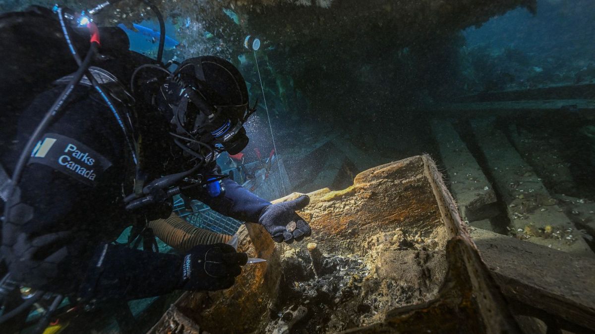 El arqueólogo subacuático de Parks Canada Marc-André Bernier excava cuidadosamente un cofre de marinero en la cubierta inferior del HMS Erebus, 14 de septiembre de 2023. 