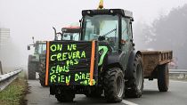 Ein Traktor mit einem Plakat mit der Aufschrift "Wir werden nicht sterben, ohne ein Wort zu sagen" ist auf einer Autobahn in der Nähe von Agen im Südwesten Frankreichs geparkt.