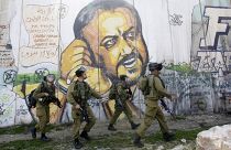 جنود إسرائيليون بجانب جدارية للأسير مروان البرغوتي في رام الله 