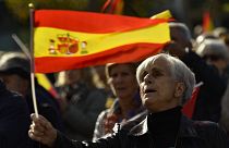 Una mujer con la bandera española mientras protesta contra la amnistía en la Plaza del Castillo, en Pamplona, norte de España, el sábado 18 de noviembre de 2023.