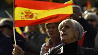 Una mujer con la bandera española mientras protesta contra la amnistía en la Plaza del Castillo, en Pamplona, norte de España, el sábado 18 de noviembre de 2023.