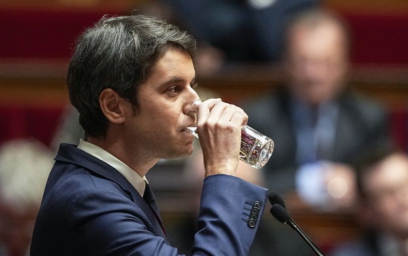French Prime Minister Gabriel Attal drinks a glass of water during his speech to the lawmakers at the National Assembly in Paris.