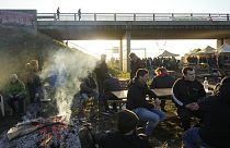 Agricoltori seduti su una barricata in un'autostrada bloccata, mercoledì 31 gennaio 2024 a Ourdy, a sud di Parigi