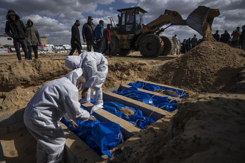 Palestinians bury the bodies of people who were killed in fighting with Israel and returned to Gaza by the Israeli military, during a mass funeral in Rafah, Gaza Strip.