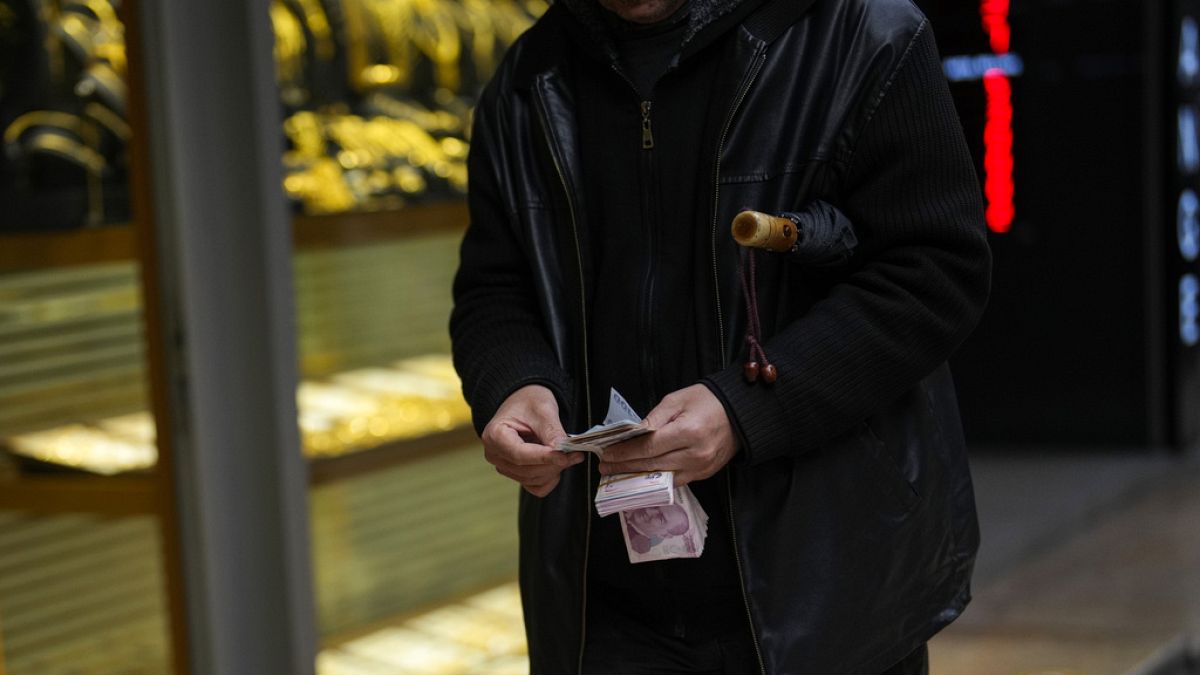İstanbul'da bir döviz bürosu önünde para sayan bir kişi