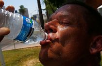 Un homme boit de l'eau en essayant de s'hydrater et de se rafraîchir alors que les températures atteignent des sommets presque record à Phoenix, États-Unis, 2017.