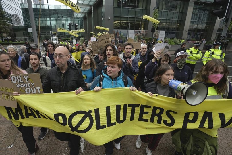 Des militants écologistes, dont Greta Thunberg, au centre à gauche, marchent avec d'autres manifestants lors de la manifestation "Oily Money Out" à Canary Wharf, à Londres